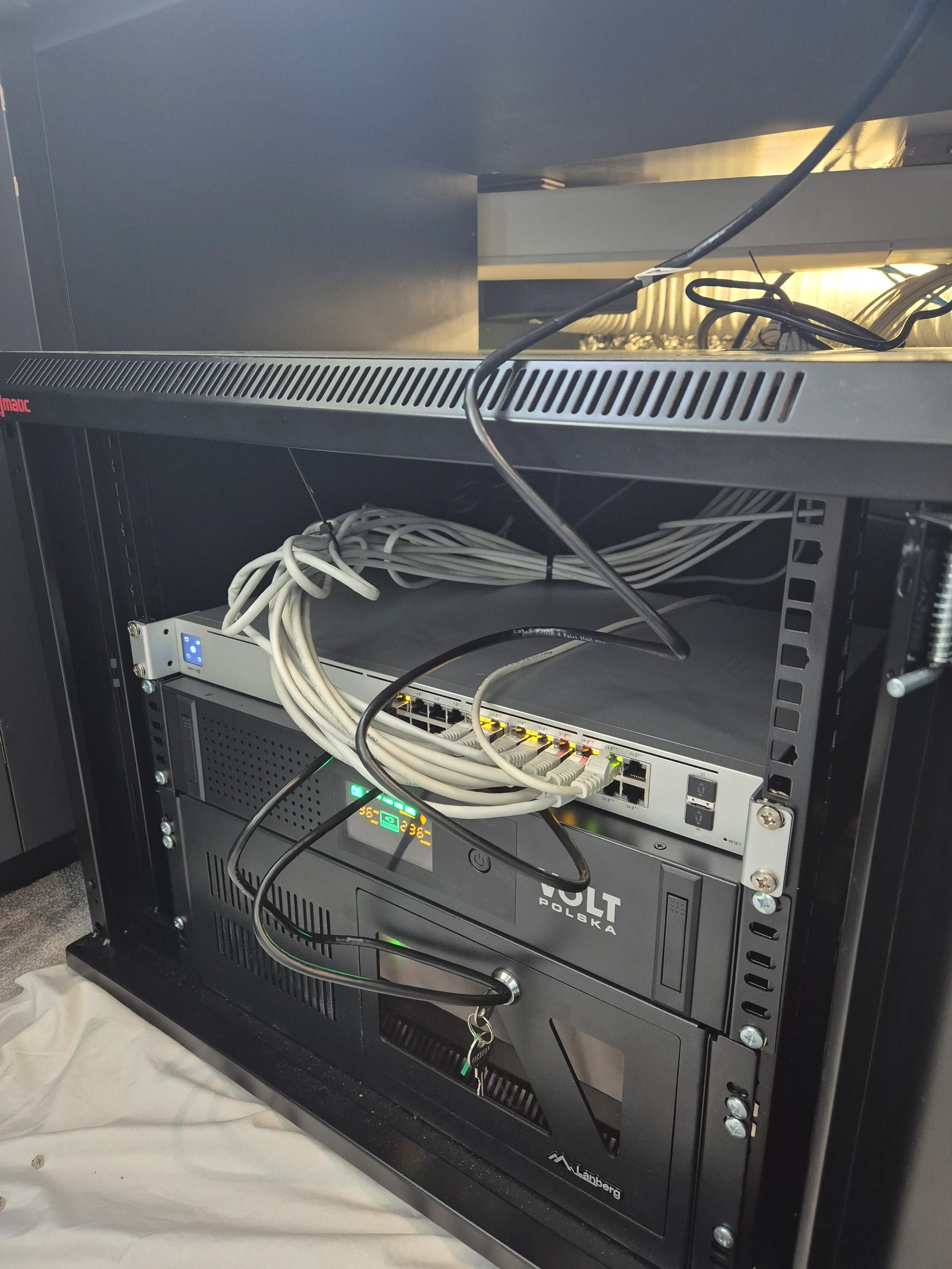 Existing onboard compute and network rack with connected cabling and equipment.